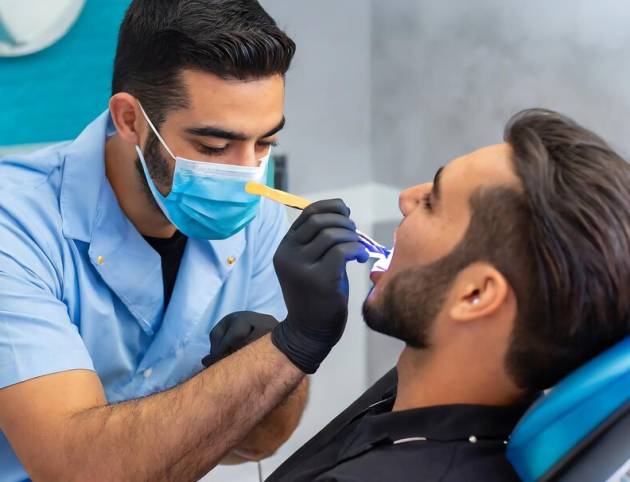 entist-making-professional-teeth-cleaning-with-wax-his-patient_793999-4351